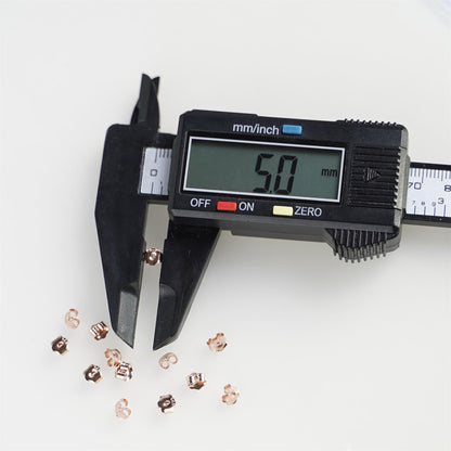 5mm rose gold butterfly earring backs next to a caliper measure