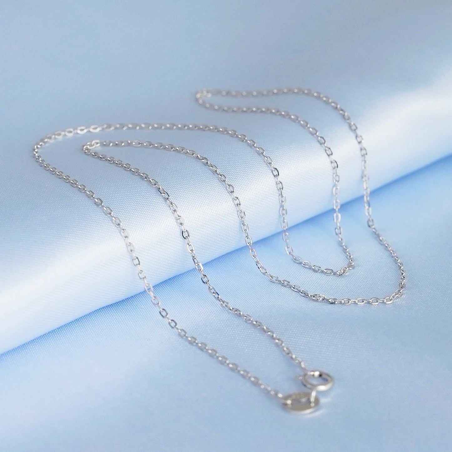 Rhodium curb belcher chain necklace with silver links draped.