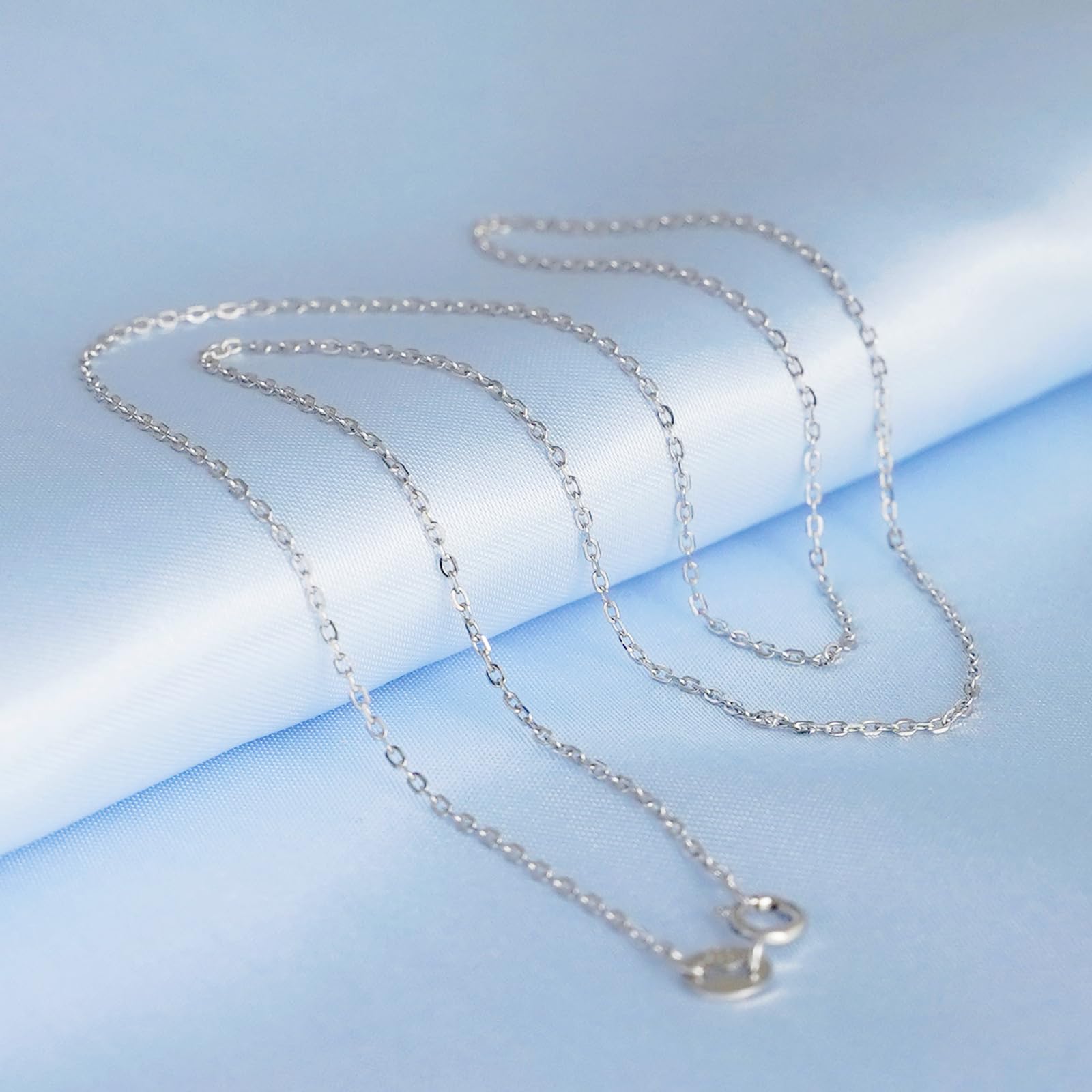 Rhodium curb belcher chain necklace with silver links draped.