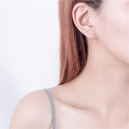 Silver spiral swirl stud earring on ear, small curled swirl design.