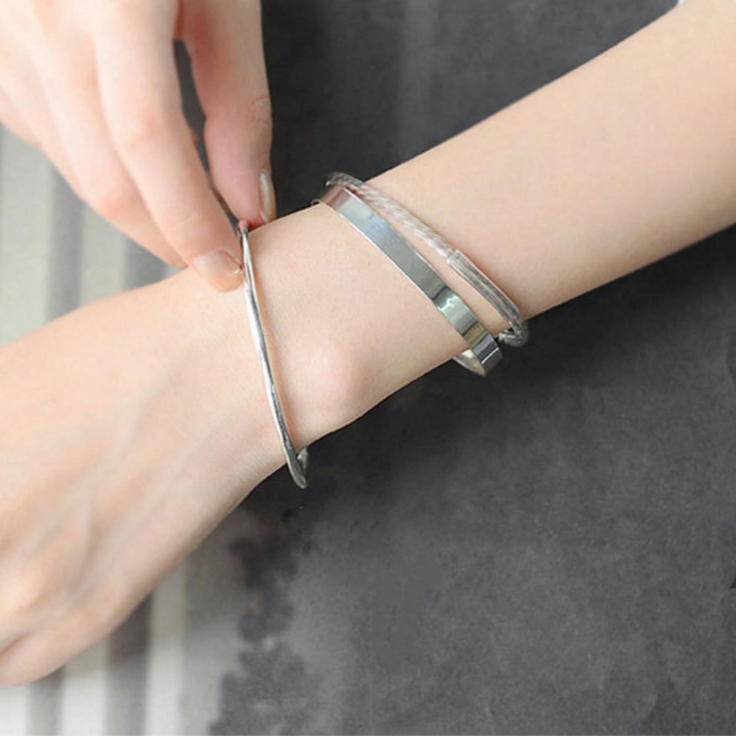 Polished cuff bangle on wrist, silver-tone cuff with layered bands look