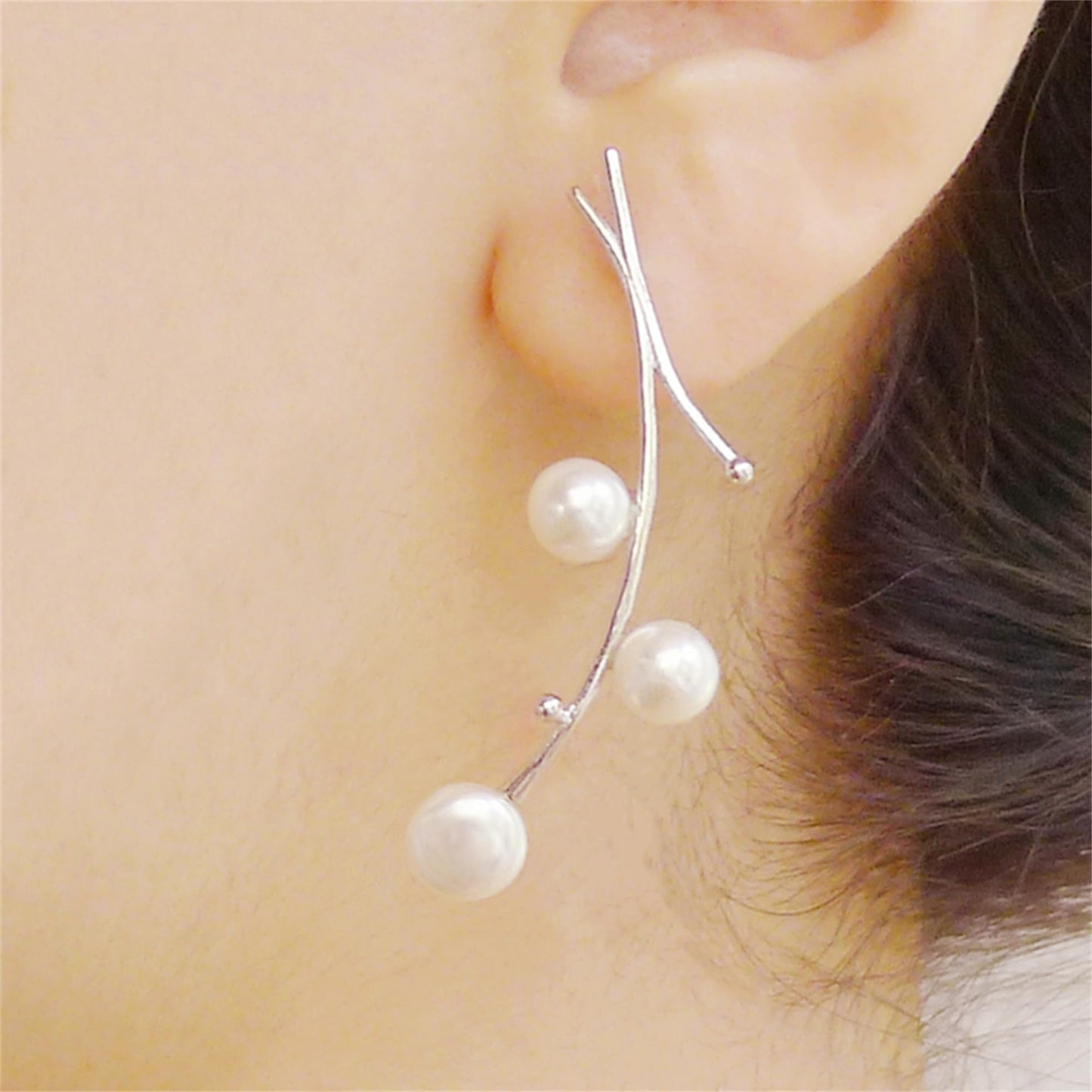 White pearl drop earrings on thin silver hooks with three dangling pearls