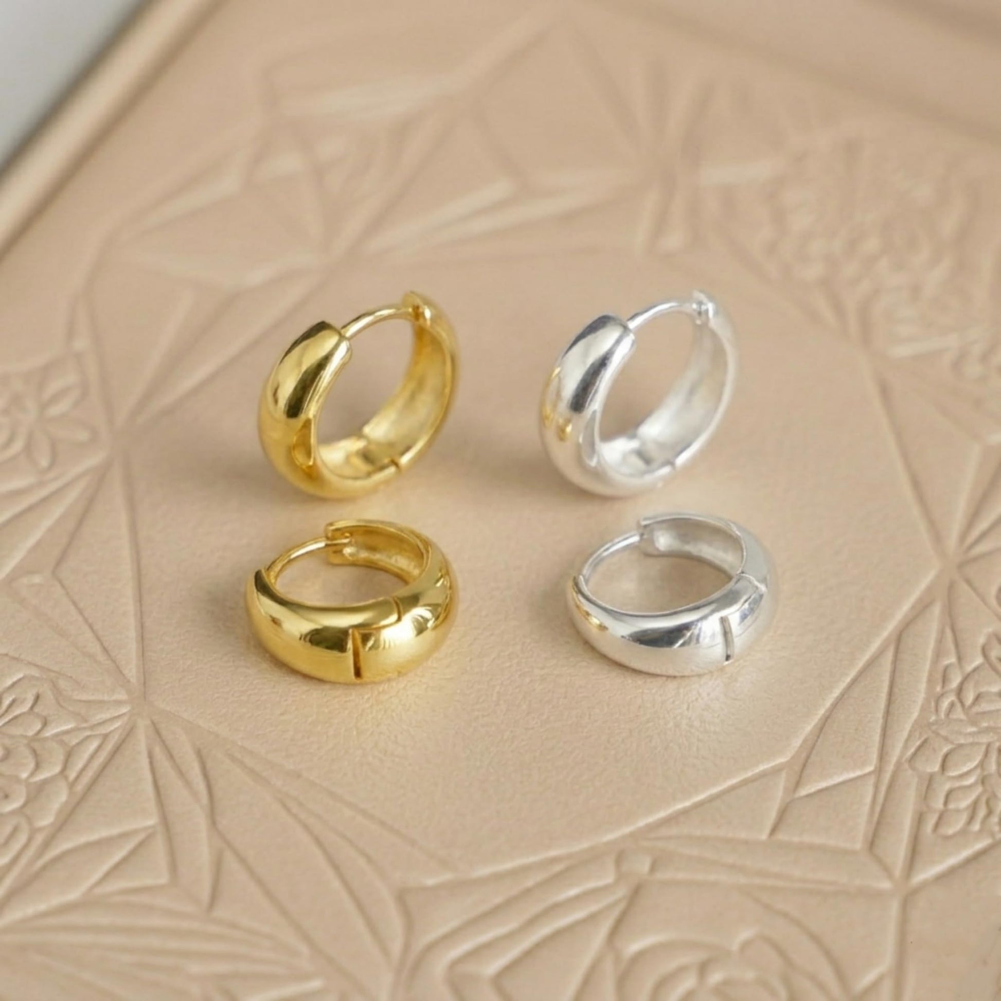 Gold and silver teardrop hoop huggie earrings set, two gold and two silver pairs.