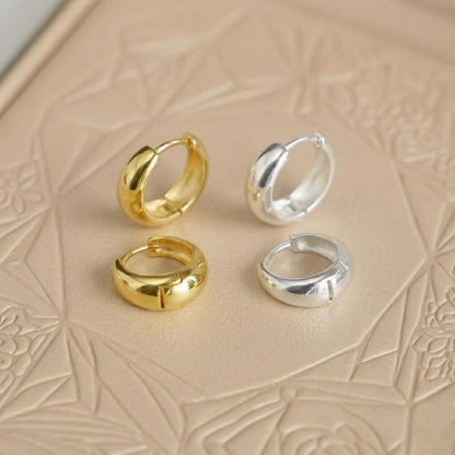 Gold and silver teardrop hoop huggie earrings set, two gold and two silver pairs.