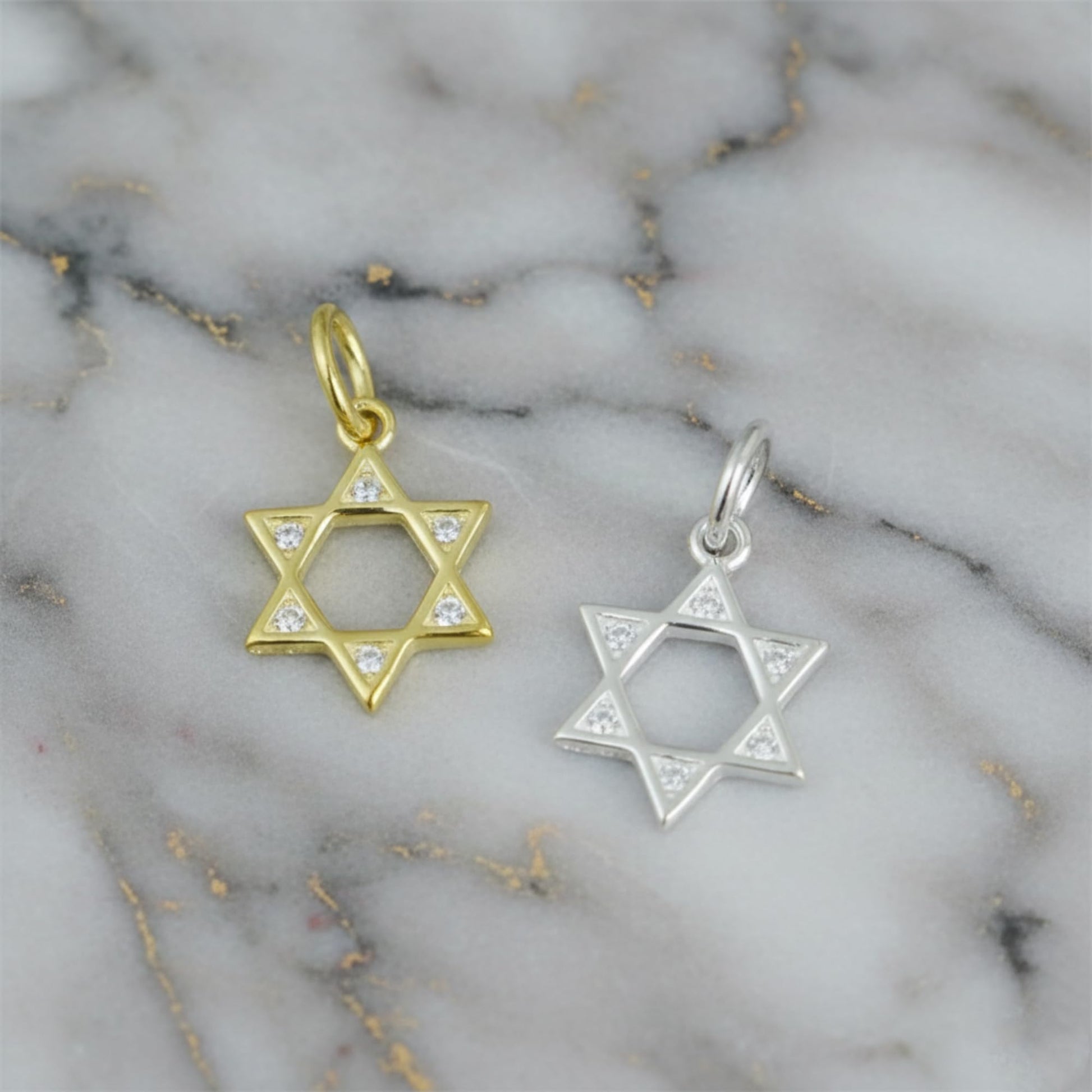 Star of David pendant charms set in gold and silver tones with small clear stones