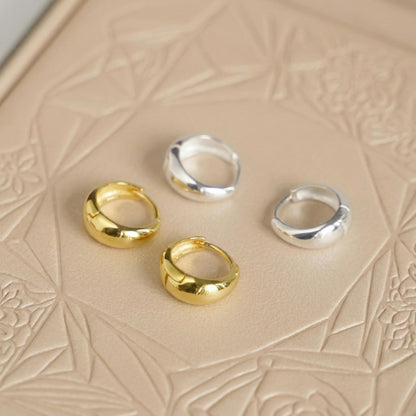 Gold and silver teardrop hoop huggie earrings set, three gold and one silver pair.