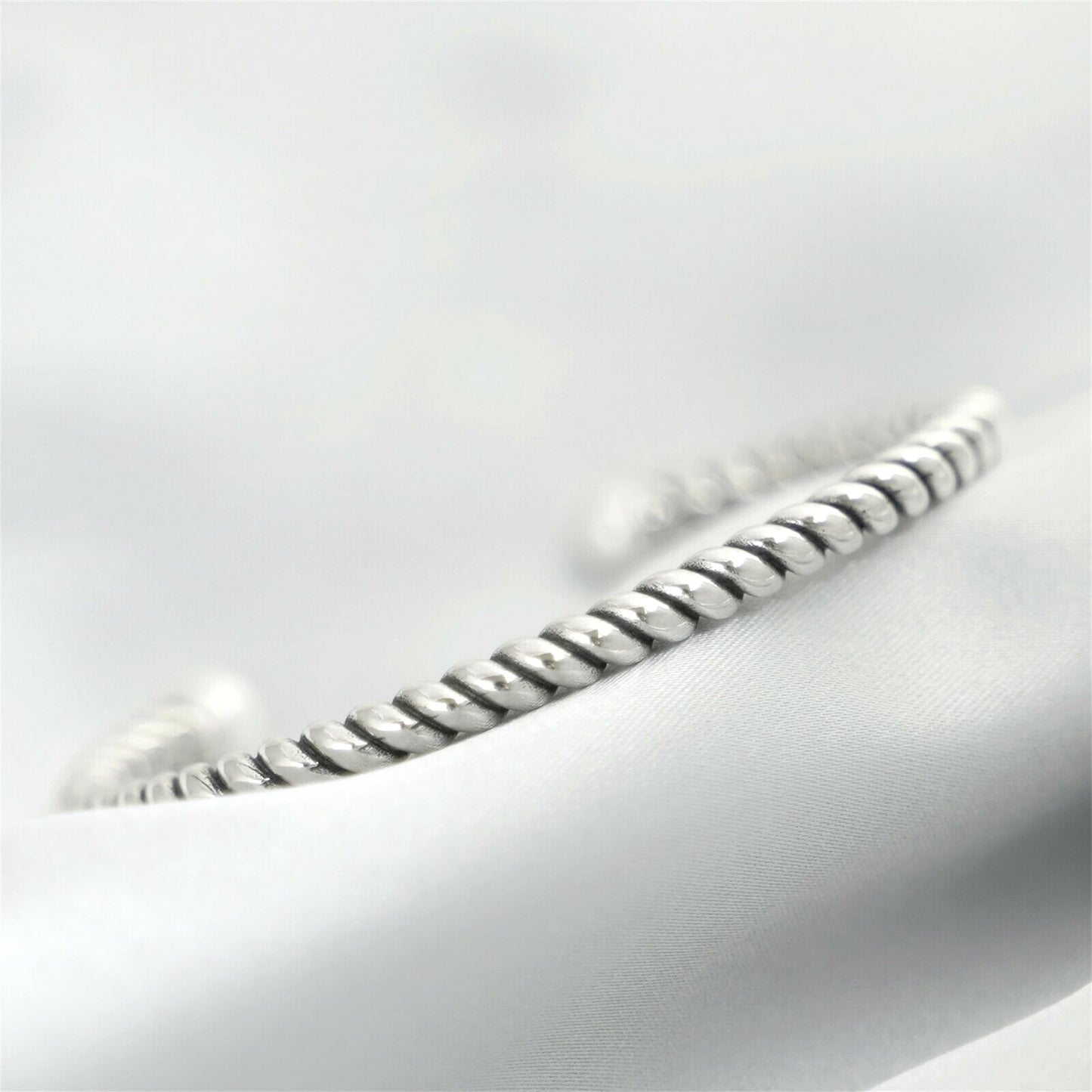 Pearl twisted torque bangle close-up of twisted silver band with white pearl end.
