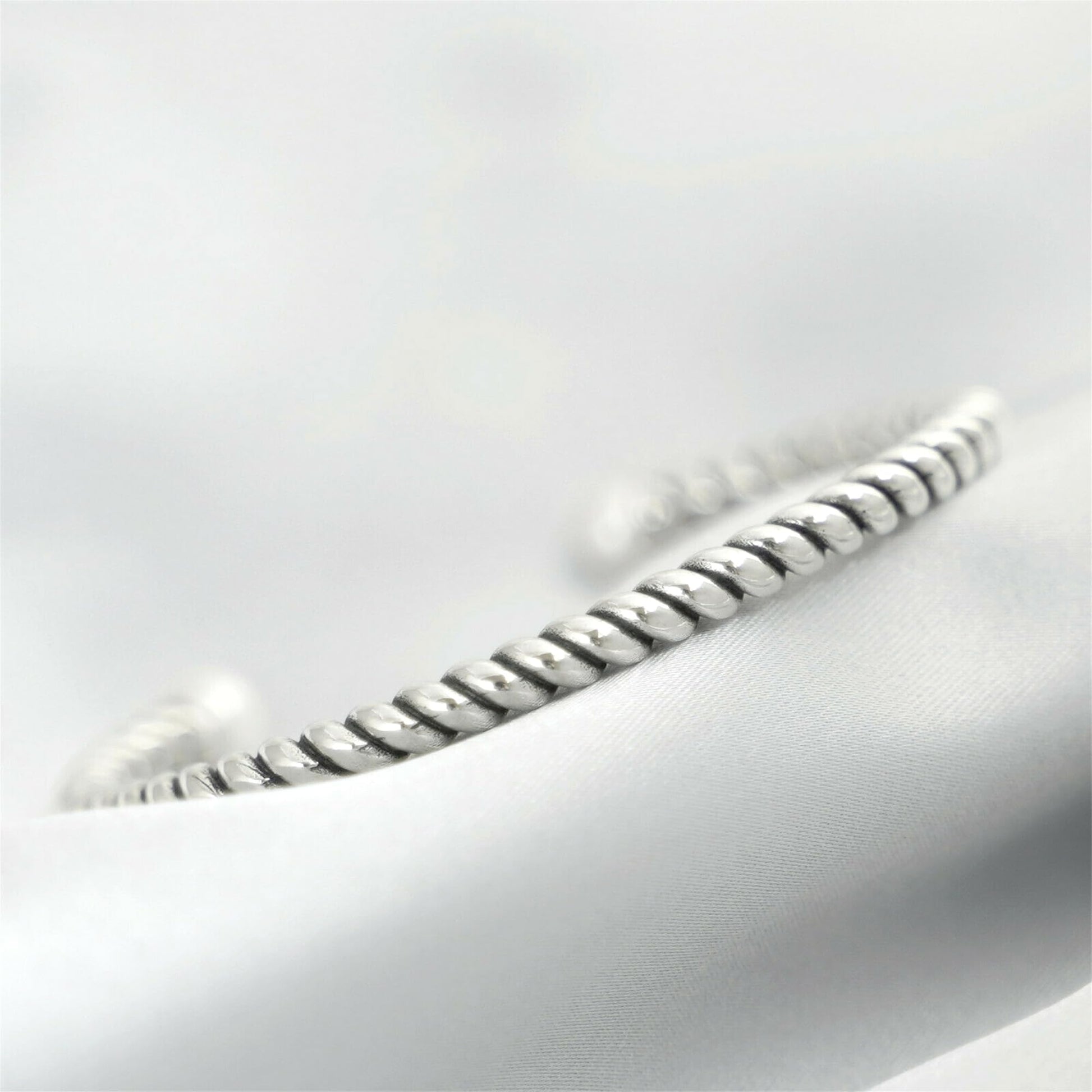 Pearl twisted torque bangle close-up of twisted silver band with white pearl end.