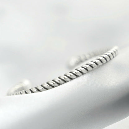 Pearl twisted torque bangle close-up of twisted silver band with white pearl end.