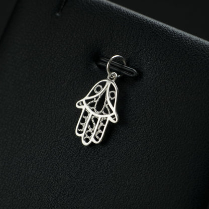 Silver hamsa hand charm pendant with detailed outline and textured filigree