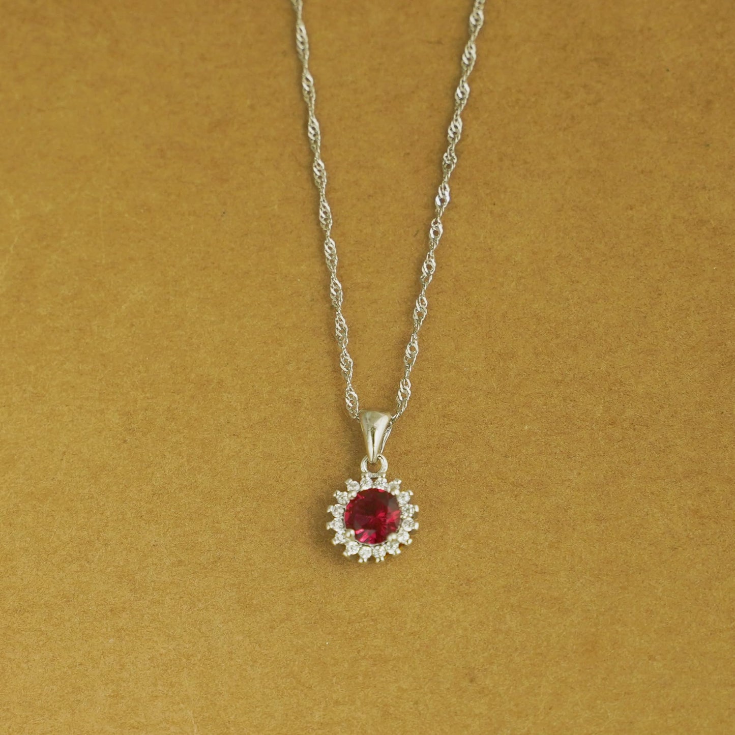 Rhodium twisted chain necklace with round red gemstone halo pendant