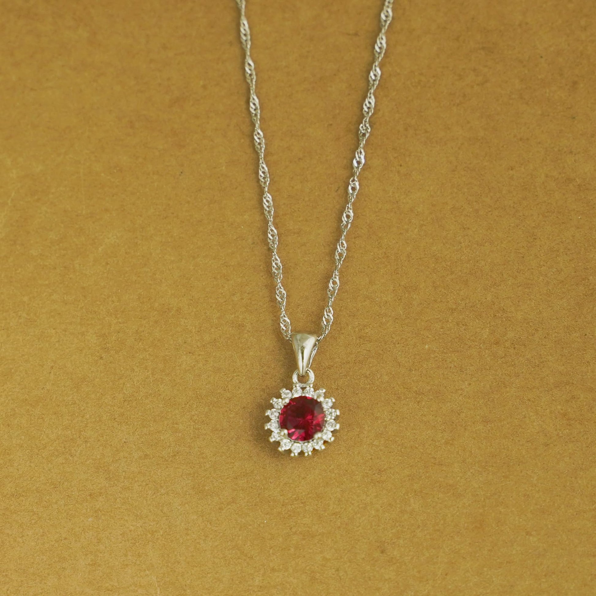 Rhodium twisted chain necklace with round red gemstone halo pendant