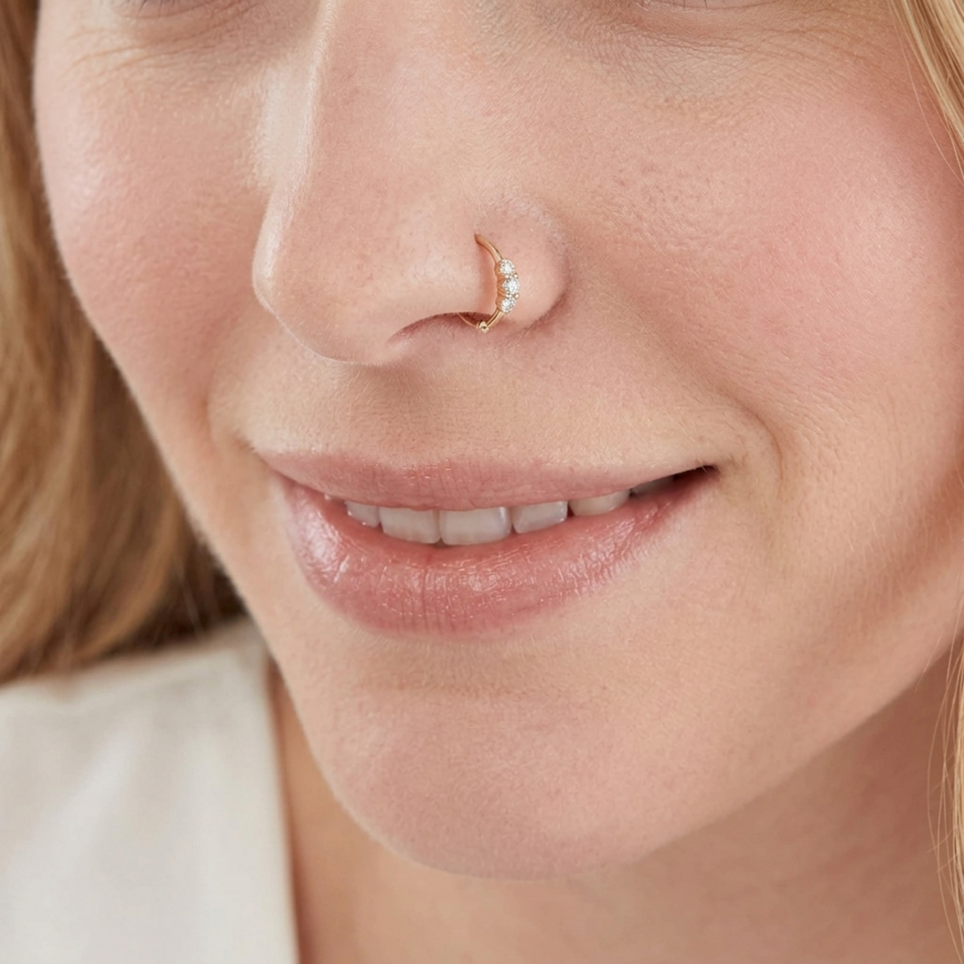 Silver CZ hoop ring with small flower cluster, worn on the nostril.