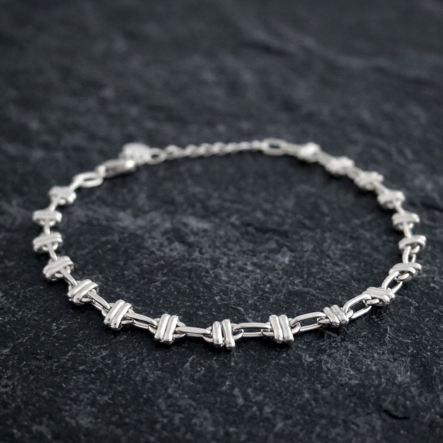 Silver-tone oval curb bracelet with alternating link segments and chain clasp