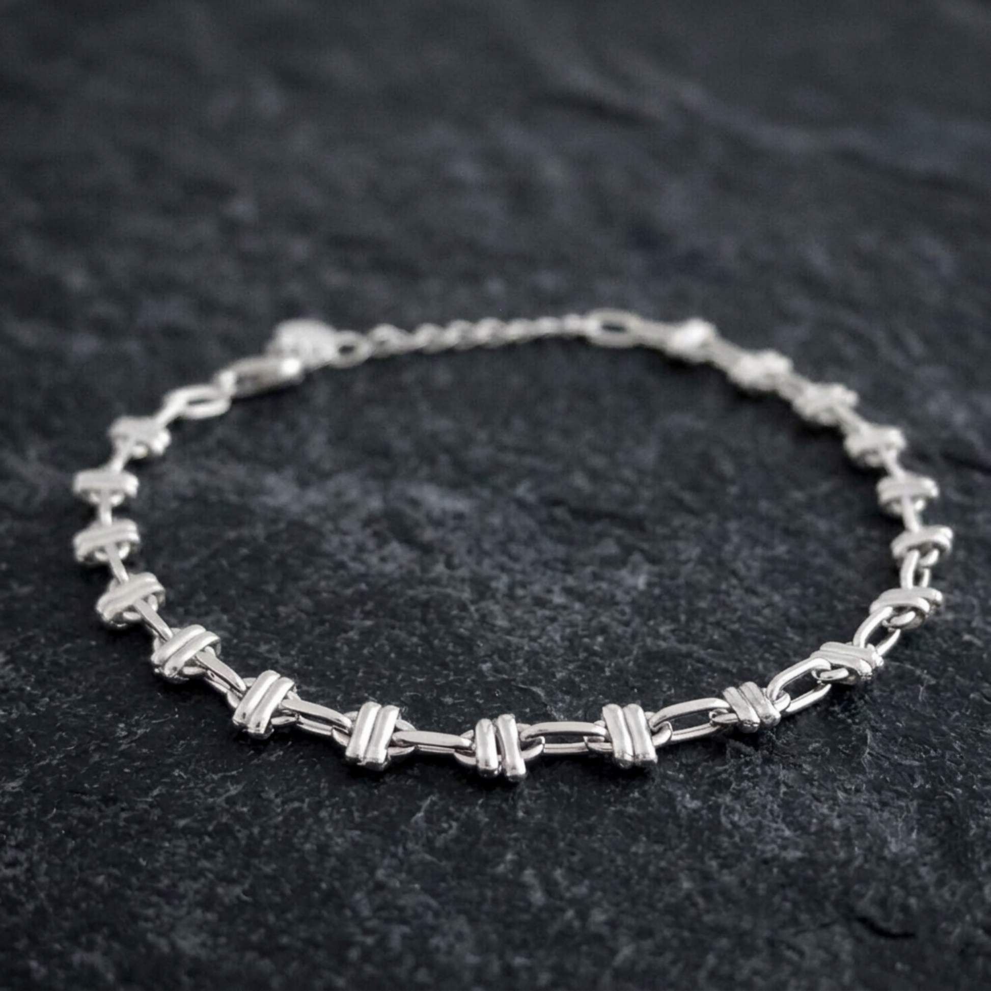 Silver-tone oval curb bracelet with alternating link segments and chain clasp