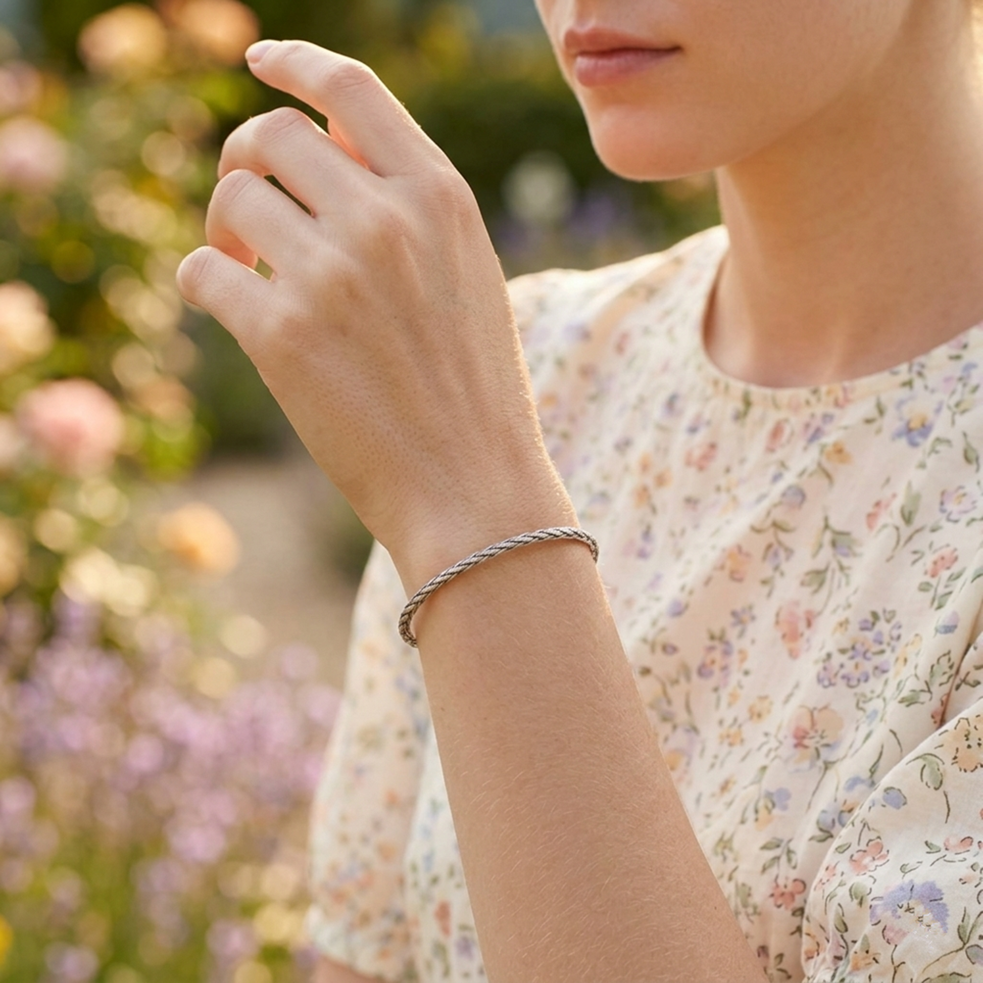 Snake-knot cuff bangle on wrist, silver-toned braided cuff with knot detail