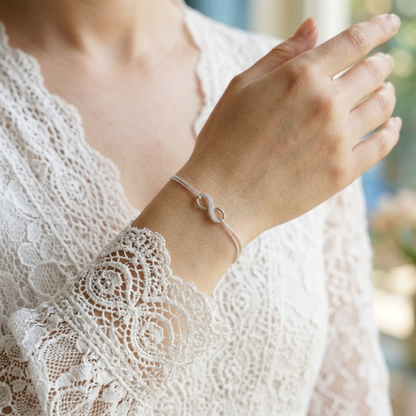 Silver infinity bracelet with oval link charms and chain on wrist