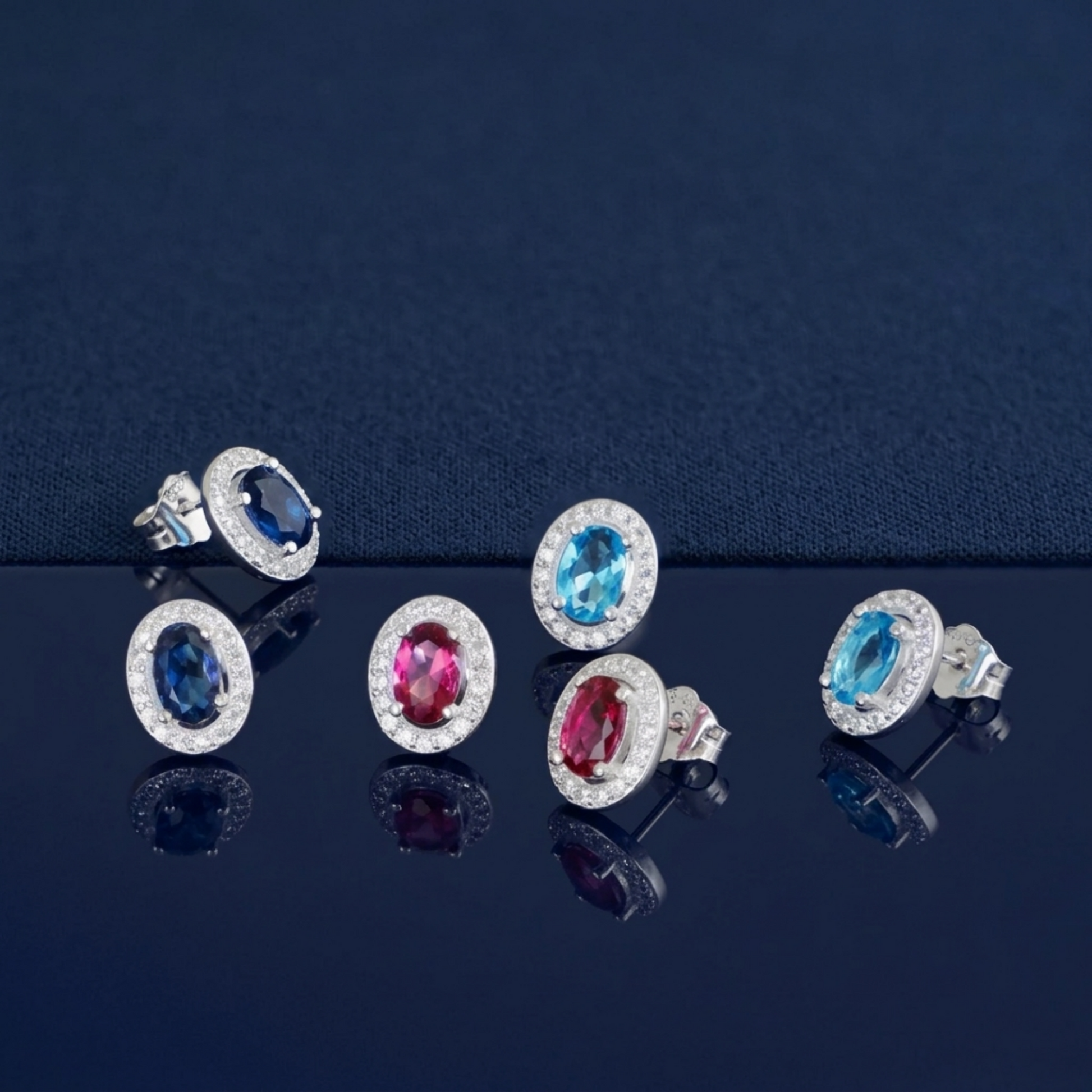 Oval halo CZ stud earrings with blue and red/pink oval stones and stud backs