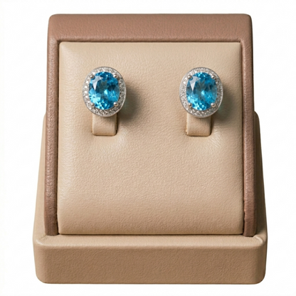 Pair of round blue gemstone stud earrings with CZ halo bezels, silver-tone