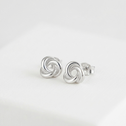 Silver knot stud earrings with butterfly backs, circular swirl detail