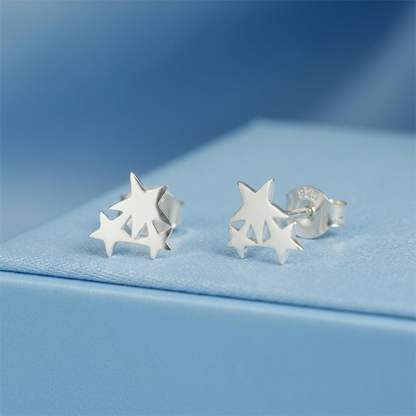 Silver triple star stud earrings with star cutouts, angled view