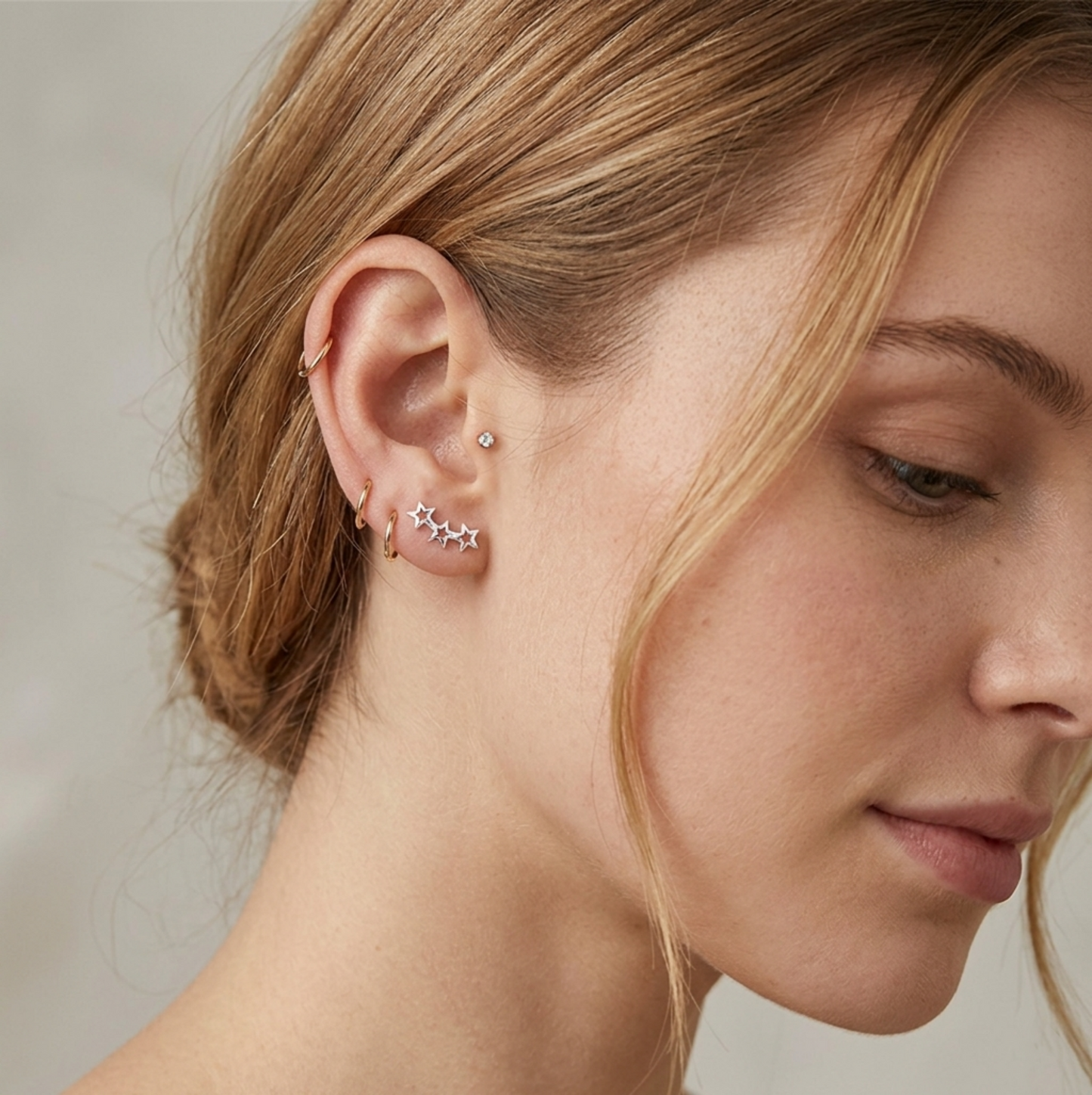 Silver-tone star ear cuff and stud set on model's ear