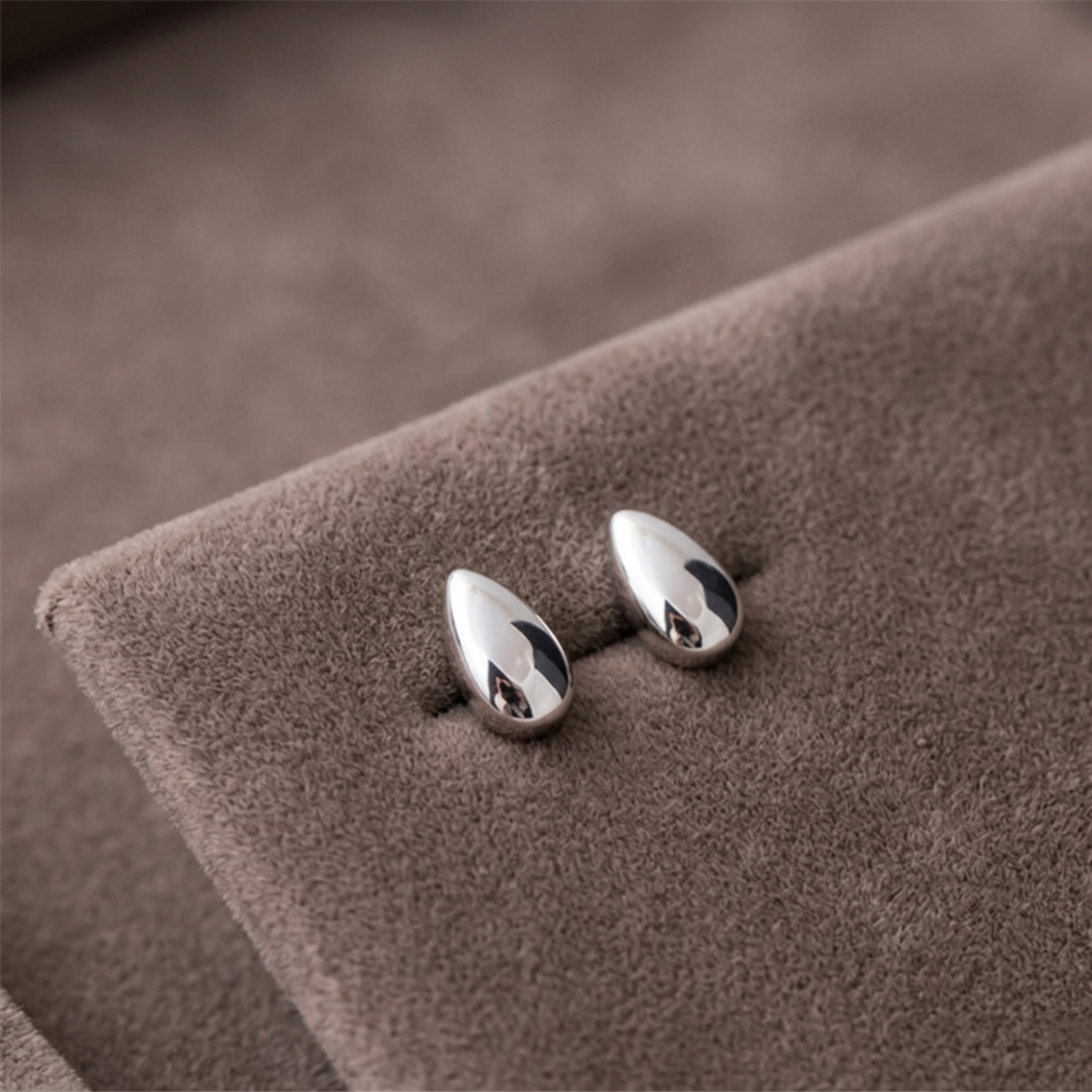 Polished rhodium teardrop stud earrings, reflective oval drop shape