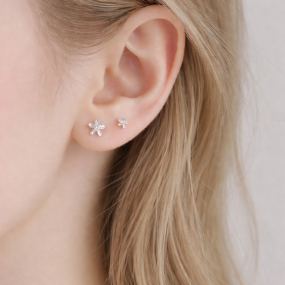 Silver lily flower stud earrings worn on ear