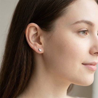 Crescent moon stud earrings on ear, silver-tone, small pair