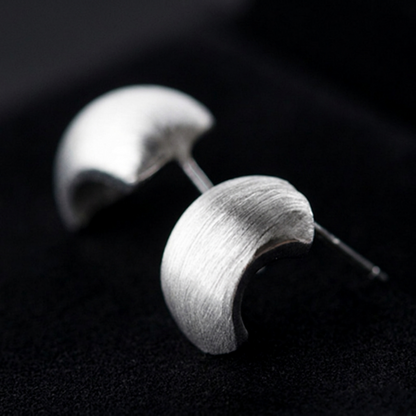 Brushed half-hoop drop earrings with silver-tone curved half-hoop and post, angled view.
