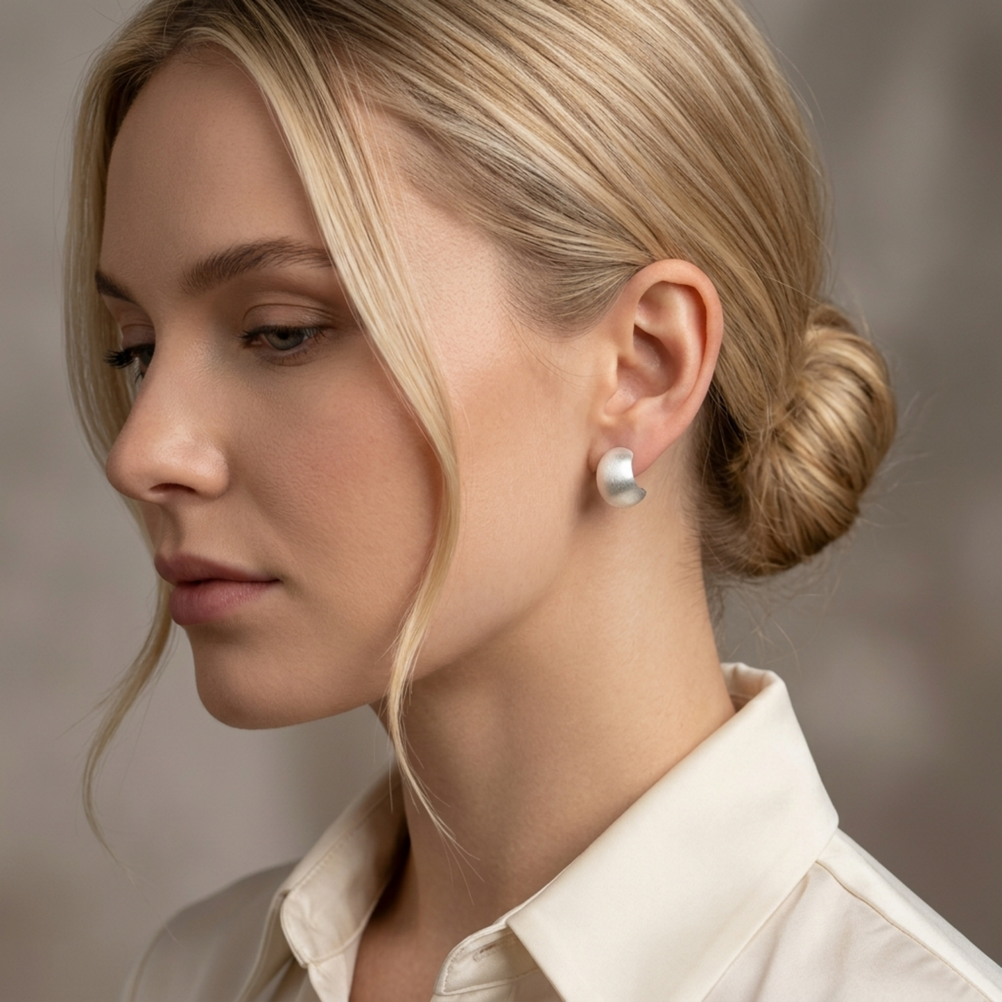 Brushed half-hoop drop earrings on model, silver-tone small open hoop with smooth brushed shine.