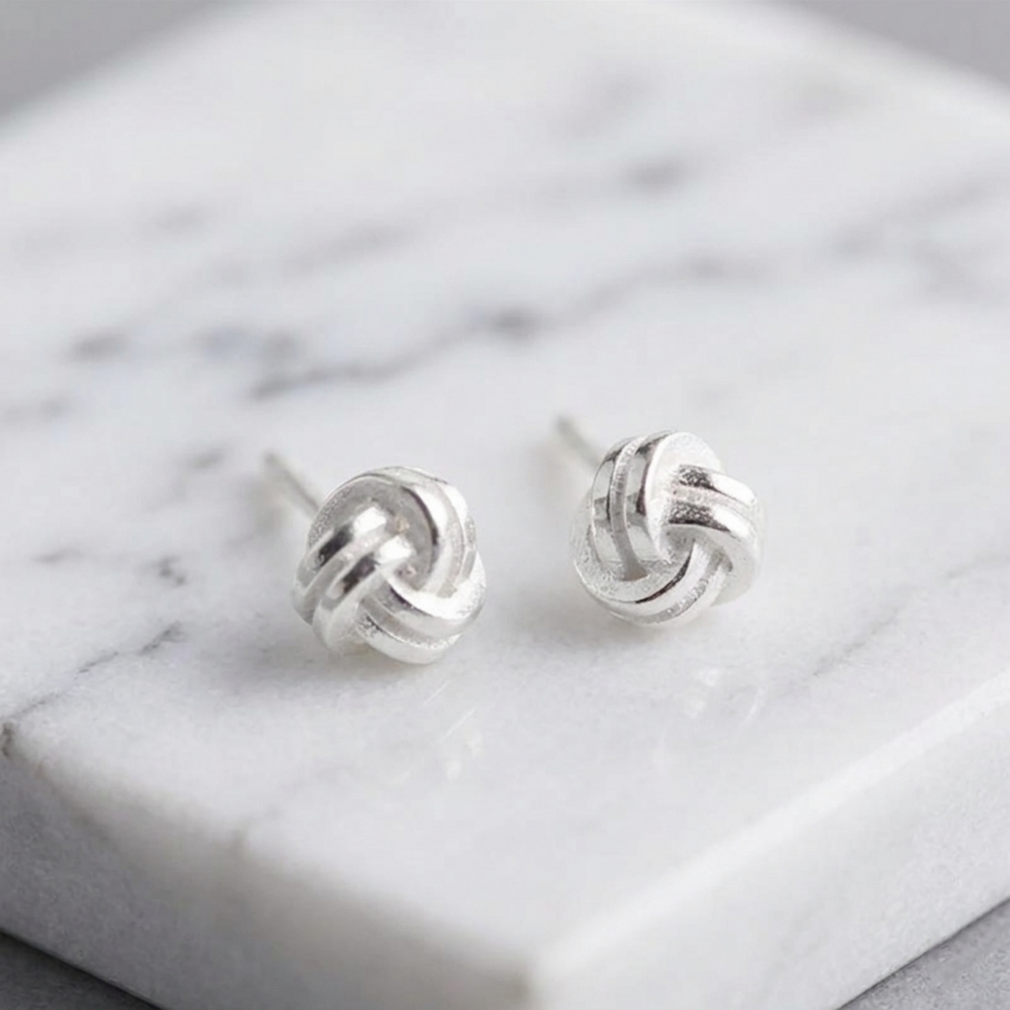 Mini love knot stud earrings, small round twisted knot motif, silver-tone
