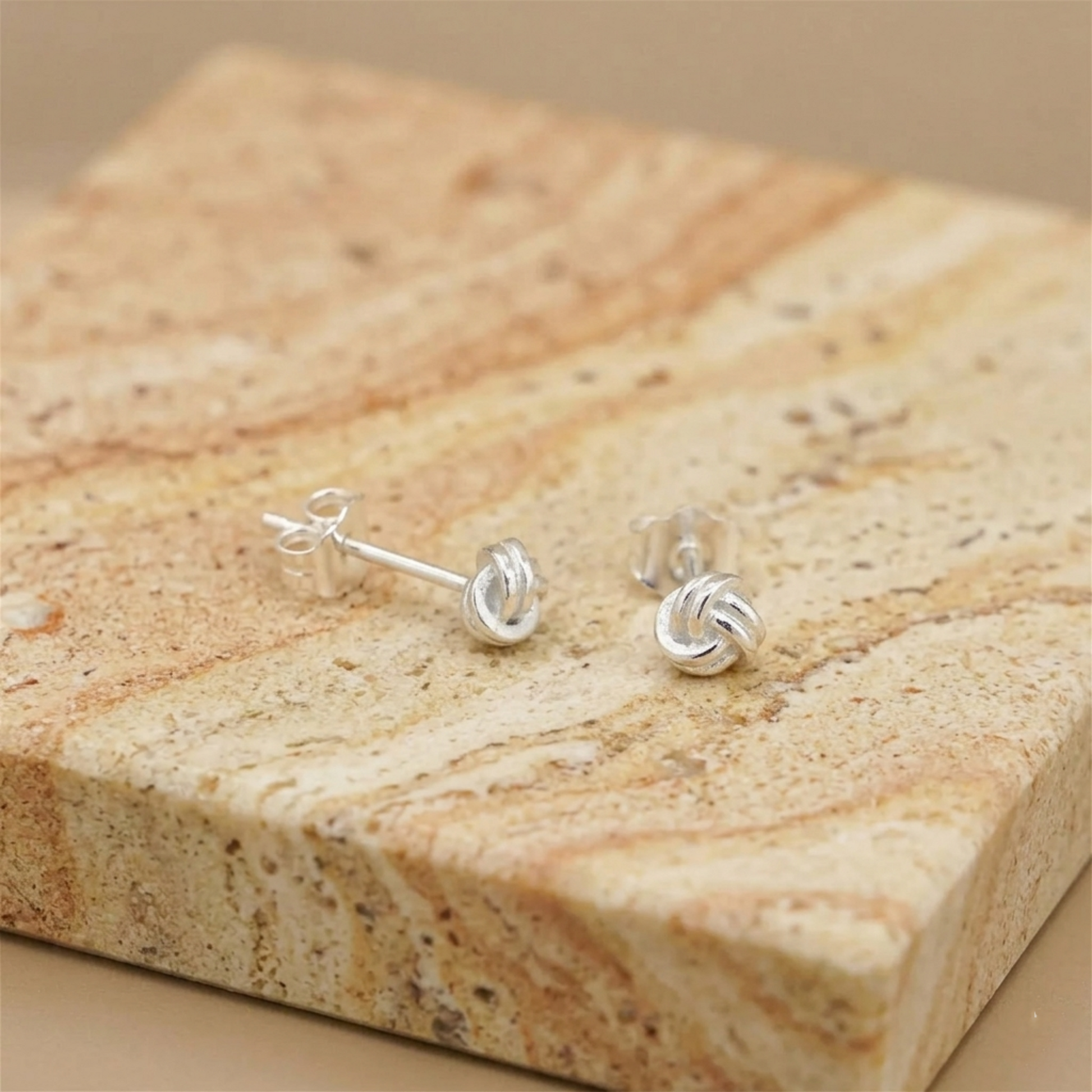 Mini love knot stud earrings with post and clasp, silver-tone twisted knot