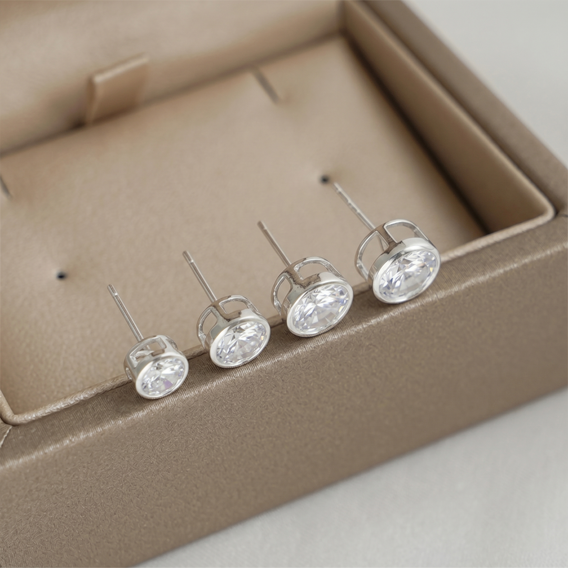 Bezel solitaire stud earrings, clear round gemstone set in silver-tone bezel