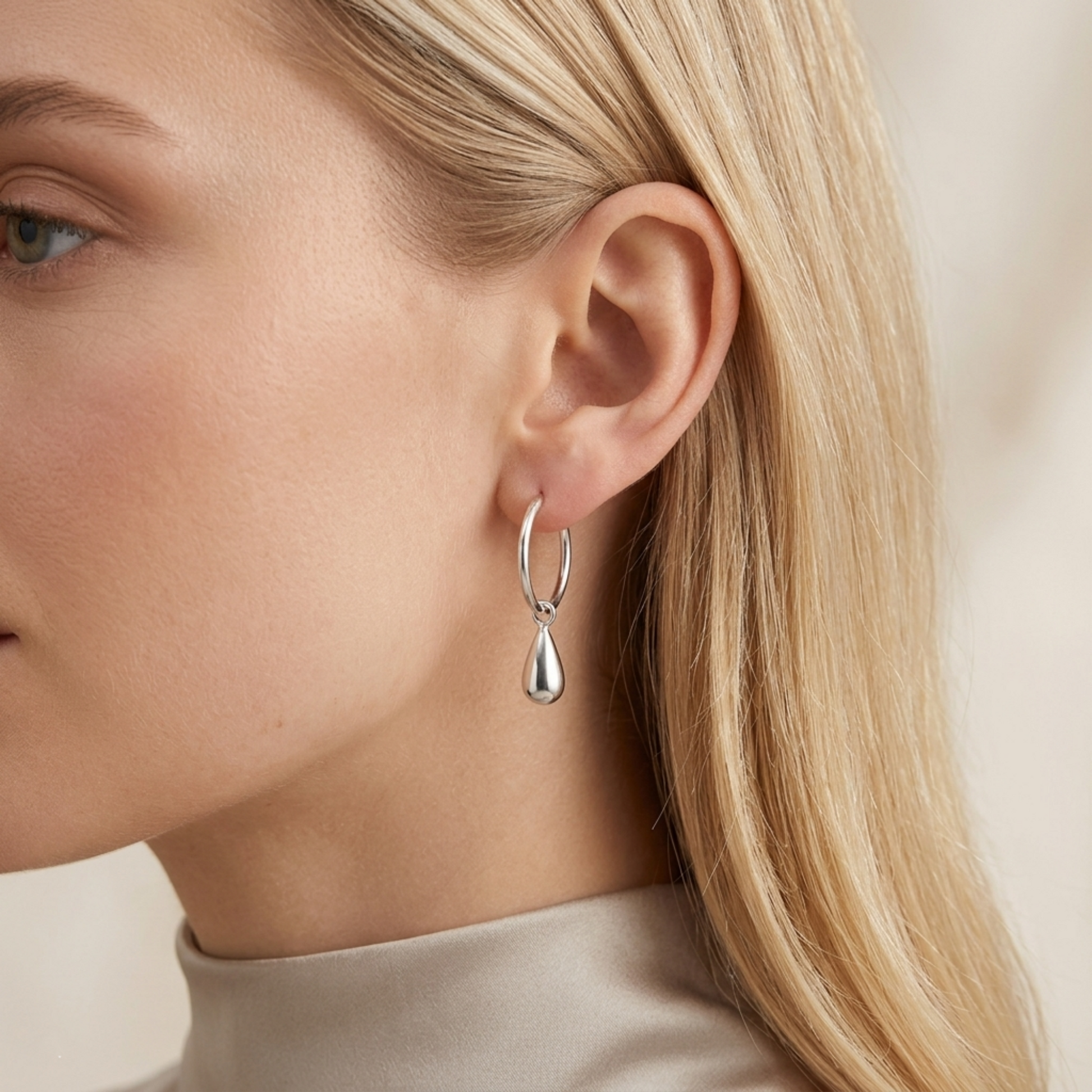 Silver teardrop hoop earrings worn, circular hoops with teardrop drops