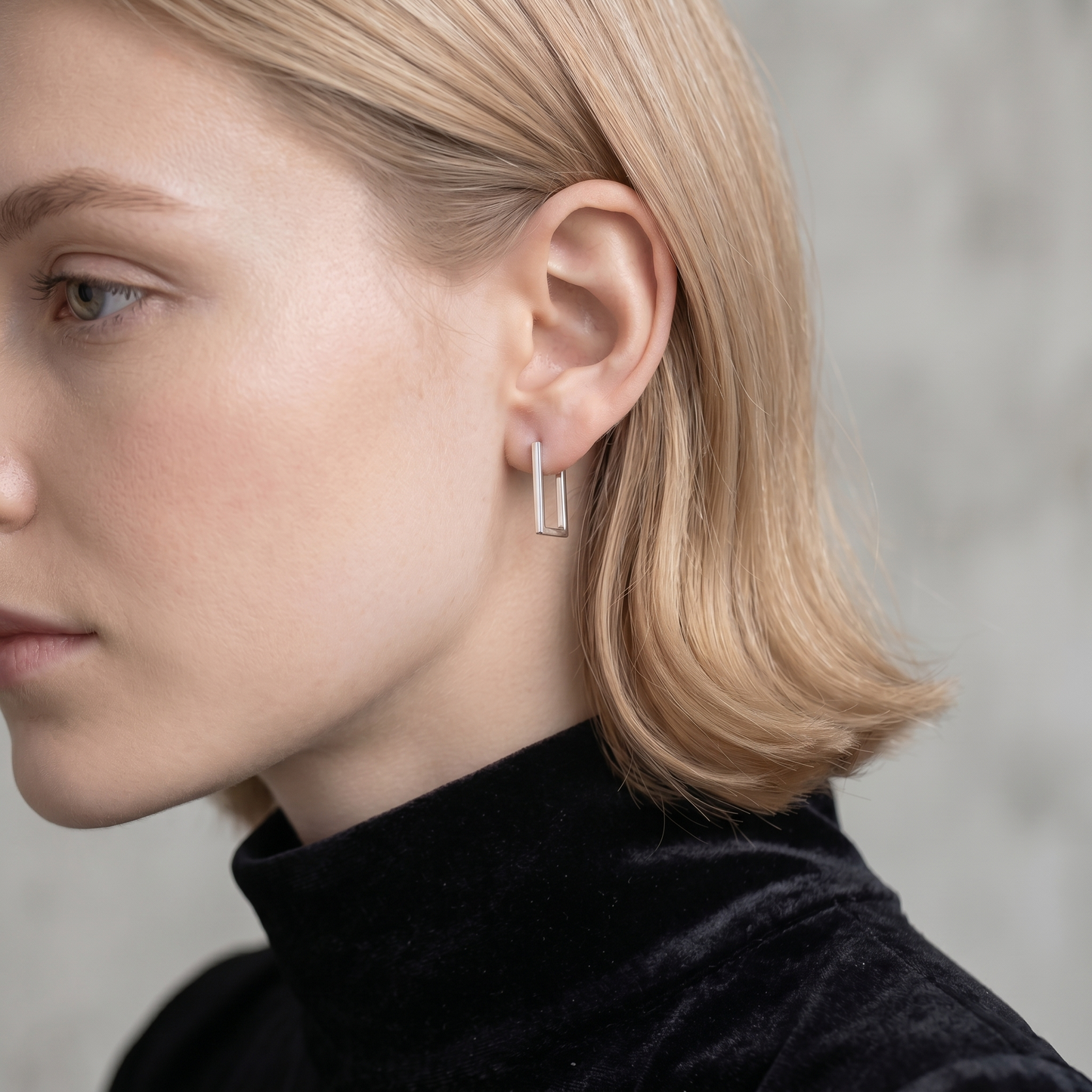 Geometric rectangle huggie earrings in silver tone on a model
