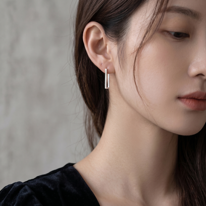 Geometric rectangle huggie earrings in silver tone on a model