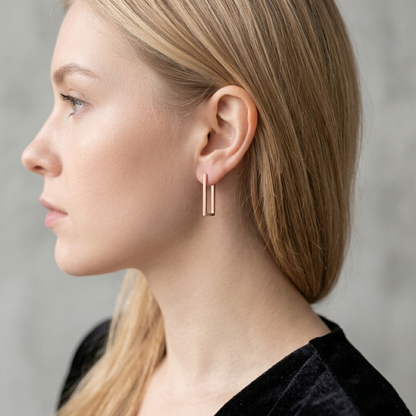 Geometric rectangle huggie earrings in gold tone on a model