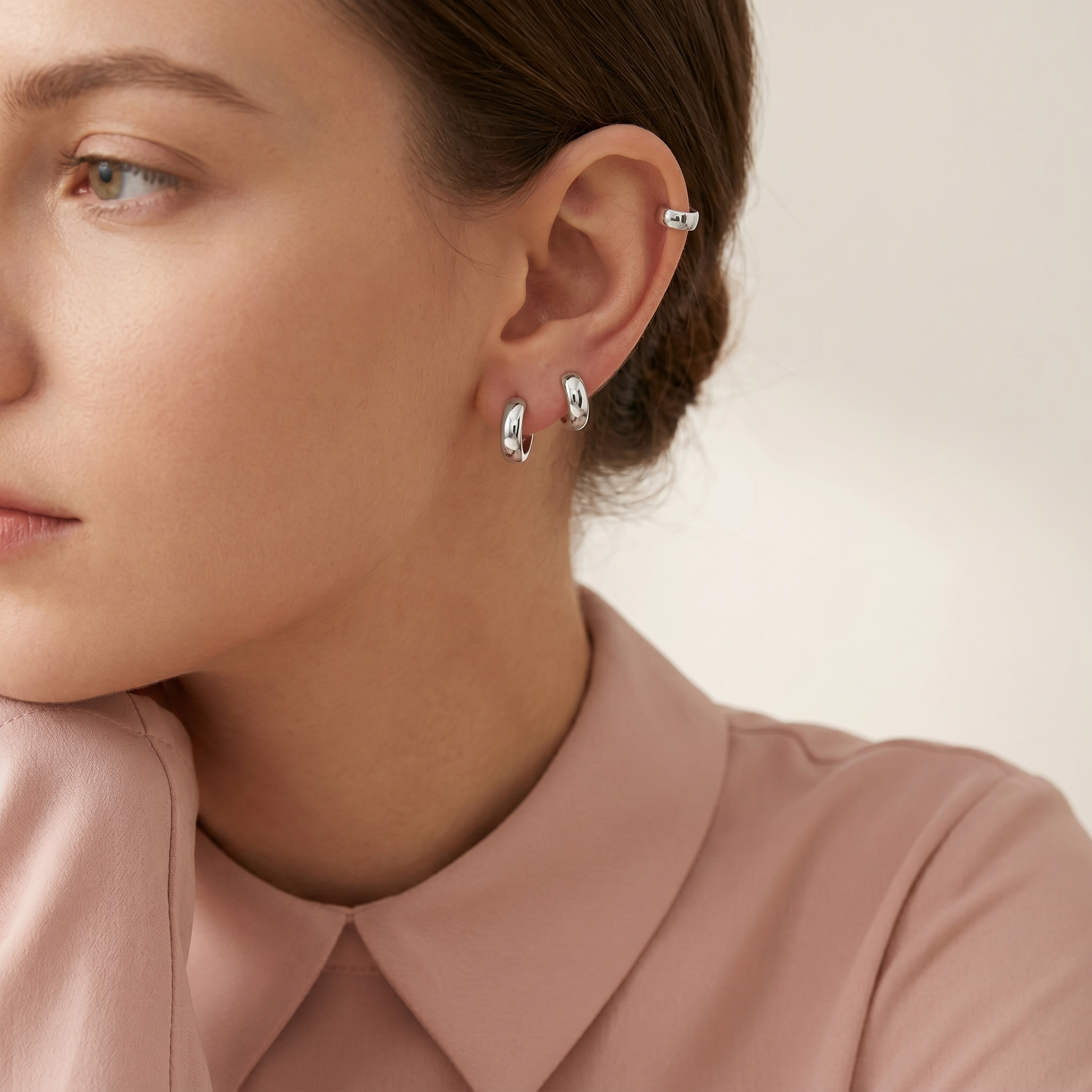 Silver sleeper huggie earrings worn on ear