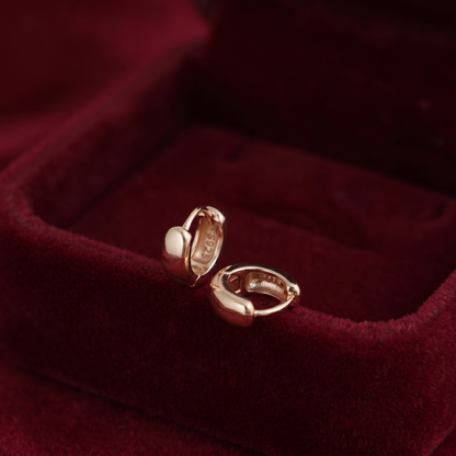 Gold sleeper huggie earrings in red velvet jewelry box