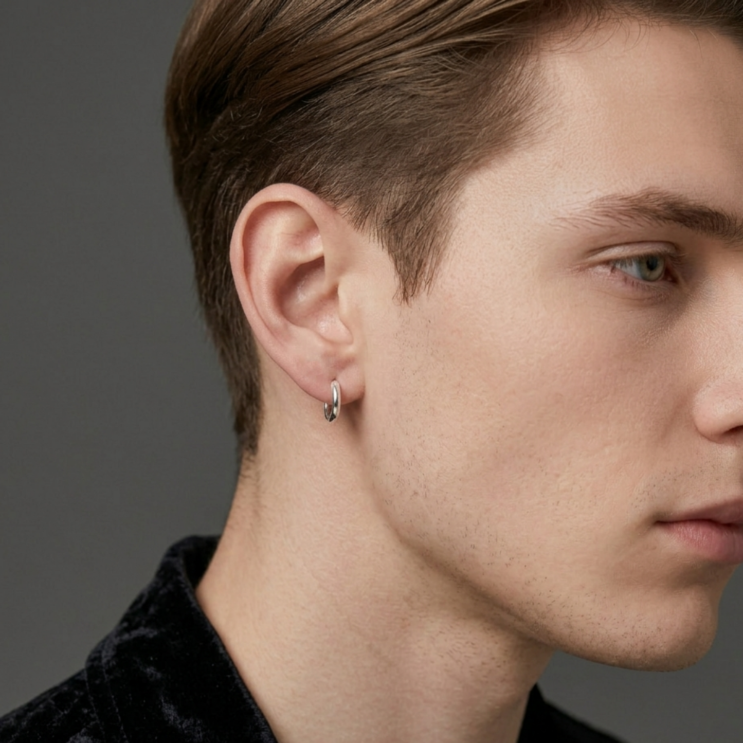 Rhodium-tone huggie hoop earrings on ear, single small hoop