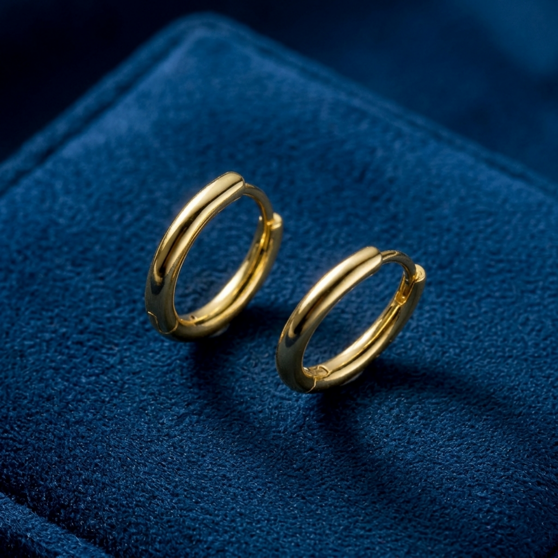 Gold-tone huggie hoop earrings with hinge detail, pair shown