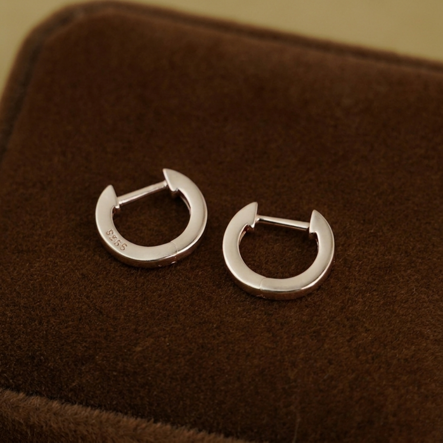 Silver latch-back hoop earrings on display, two-piece pair