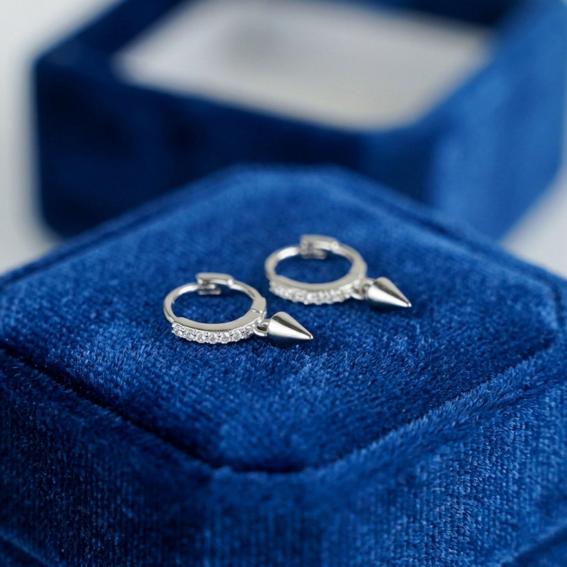 Silver cone-spike hoop earrings with sparkling pavé band and pointed charms