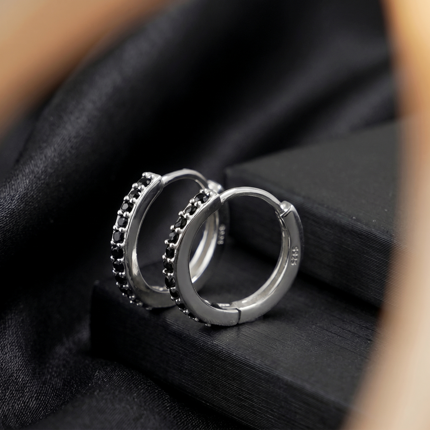 Contrast Huggie Hoops in Black with dark stones on silver-tone hoops