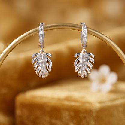 Monstera Leaf Drop Huggies on display: hinged silver hoops with Monstera leaf charms