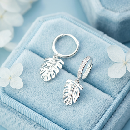 Monstera Leaf Drop Huggies: small hinged hoops with clear-stone band and leaf drops