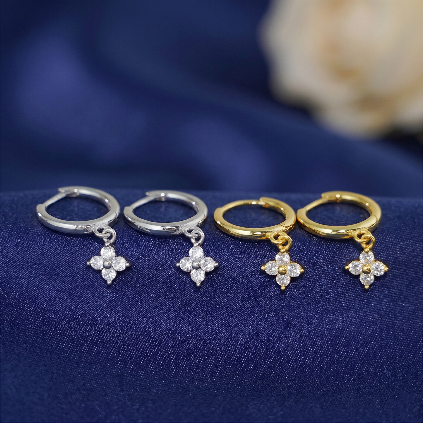 Huggie hoop earrings set in silver and gold with flower charms and crystals