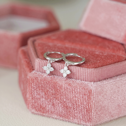 Silver huggie hoop earrings with four-petal flower charm and small crystals