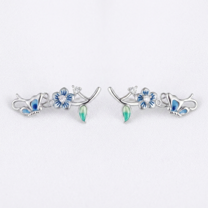 Silver butterfly climber earrings with blue enamel flowers and green teardrop drops